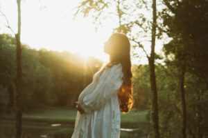 Femme enceinte sereine portant un bola de grossesse au coucher du soleil