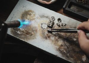 Artisan soudant au chalumeau le filigrane en argent d un bola de grossesse