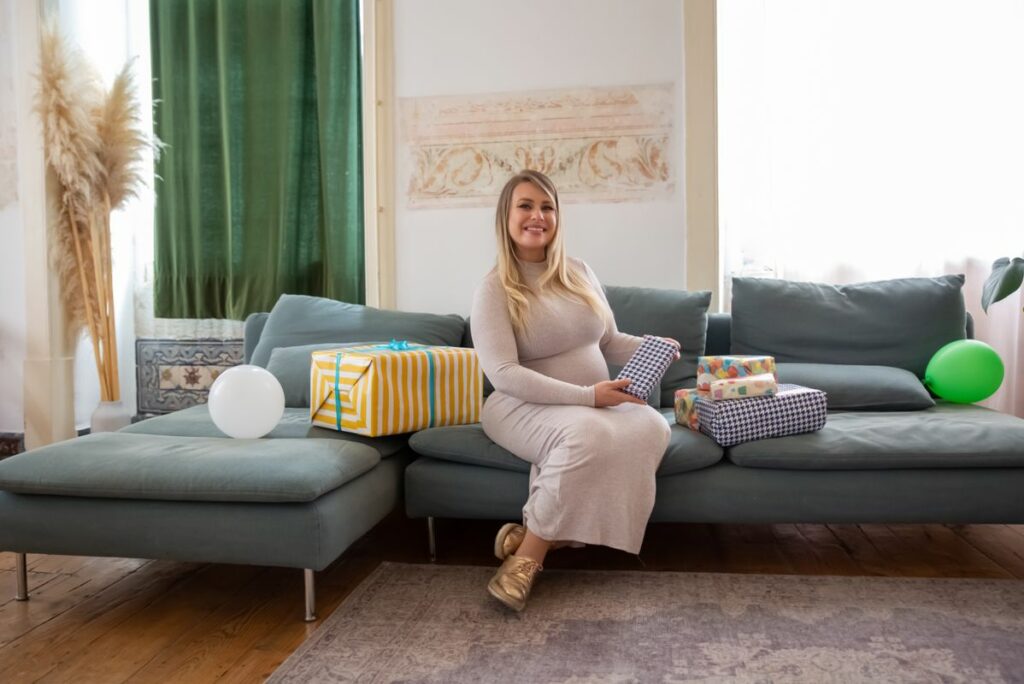 Future maman souriante recevant un bola de grossesse en cadeau lors d un baby shower